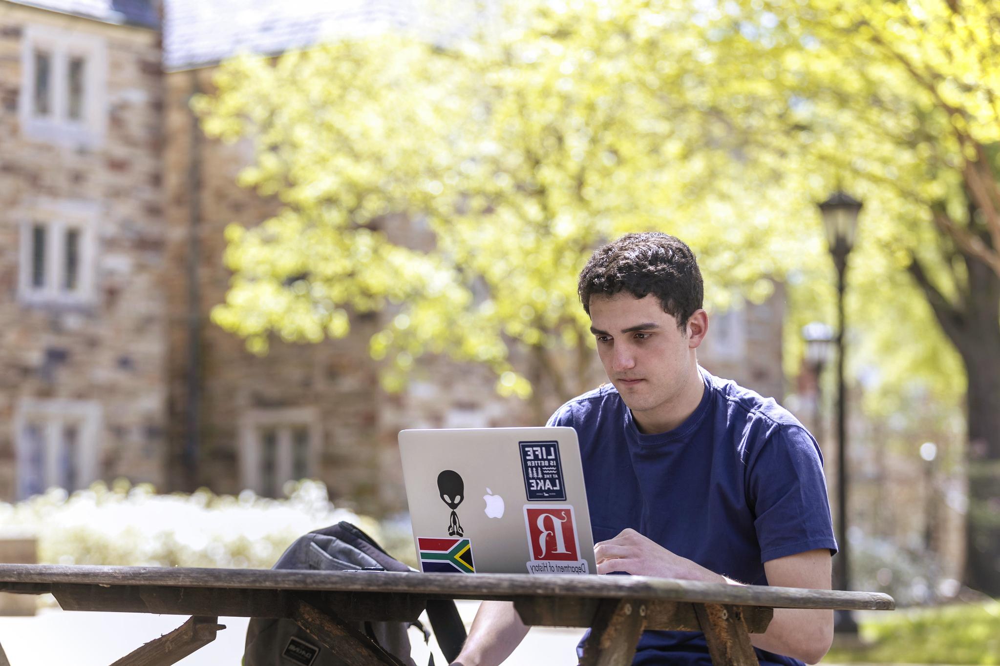 a male student looking at a laptop