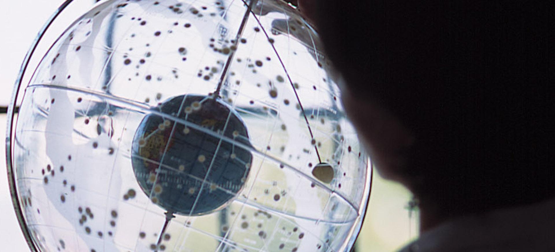 a student examining a clear globe