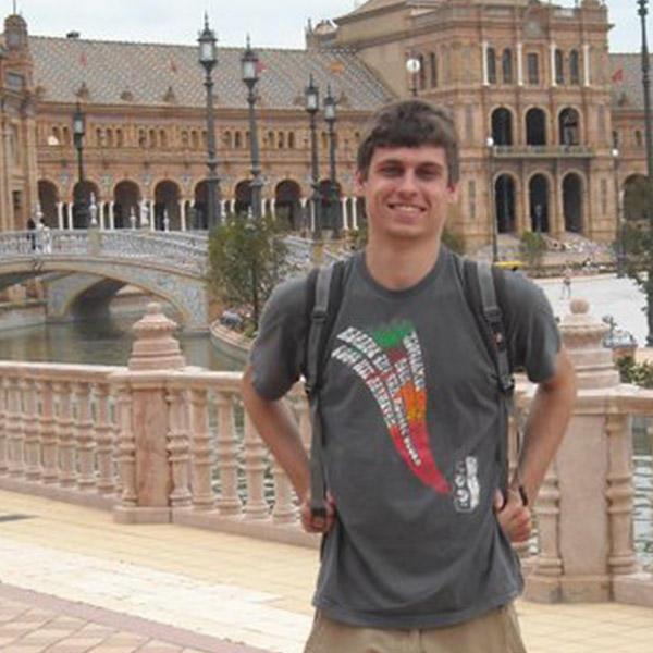 一个背着背包的年轻人站在西班牙广场前